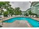 Inviting community pool surrounded by lounge chairs and lush landscaping, perfect for relaxation and recreation at 5905 S Kings Hwy. # A551, Myrtle Beach, SC 29575
