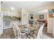 Open floor plan with a dining area featuring a glass table, wicker chairs, and views into the living room and kitchen at 5905 South Kings Hwy. # 132-A, Myrtle Beach, SC 29575