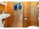 Bathroom featuring wood paneling, towel rack, sink with liquid soap dispenser, and toilet at 600 Hillside Dr. S, North Myrtle Beach, SC 29582