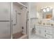 Bathroom showcasing a shower-tub combo with glass door, white tile, toilet, and sink with cabinet at 600 Hillside Dr. S, North Myrtle Beach, SC 29582
