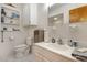Bright bathroom with white tile, toilet, vanity with sink, and cabinet for toiletries at 600 Hillside Dr. S, North Myrtle Beach, SC 29582