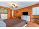 Bedroom featuring wooden walls, a bed with brown comforter, white dressers, and ceiling fan at 600 Hillside Dr. S, North Myrtle Beach, SC 29582