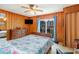 Bedroom featuring wooden walls, a floral bed spread, balcony access, and a ceiling fan at 600 Hillside Dr. S, North Myrtle Beach, SC 29582