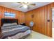Bedroom featuring wooden walls, a bed with stripped bedding, a night stand, and a ceiling fan at 600 Hillside Dr. S, North Myrtle Beach, SC 29582