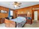 Bedroom featuring wooden walls, a floral bed spread, dark wooden furniture, and a ceiling fan at 600 Hillside Dr. S, North Myrtle Beach, SC 29582
