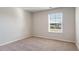 A simple bedroom with neutral carpet and walls, a window lets in natural light at 616 Culmen Ct., Myrtle Beach, SC 29588