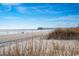 Scenic beach view with a pier extending into the ocean under a blue sky at 625 N Waccamaw Dr. # 301, Murrells Inlet, SC 29576