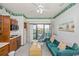 Bright living space featuring a sofa, kitchenette, and balcony access with outside views at 625 N Waccamaw Dr. # 301, Murrells Inlet, SC 29576