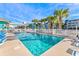 Community swimming pool surrounded by lounge chairs and lush palm trees at 625 N Waccamaw Dr. # 301, Murrells Inlet, SC 29576