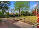Spacious backyard with brick patio, garden beds, and lush greenery, ideal for outdoor activities at 708 48Th Ave. N, Myrtle Beach, SC 29577
