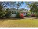 Landscaped backyard featuring flowering bushes, grass, and a view of the home's exterior at 708 48Th Ave. N, Myrtle Beach, SC 29577