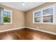 Sunlit bedroom with hardwood floors, neutral walls, and windows with views of the greenery outside at 708 48Th Ave. N, Myrtle Beach, SC 29577