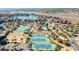 Aerial view showcasing lush community tennis courts, pool, and surrounding condos nestled by a serene lake at 741 Retreat Beach Circle # B-1-F, Pawleys Island, SC 29585