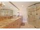 A bathroom featuring a double vanity with a granite countertop and a glass-enclosed shower with a seat at 741 Retreat Beach Circle # B-1-F, Pawleys Island, SC 29585