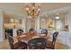 An elegant dining area features a round table, ornate chandelier, and seamless transition into a modern, well-equipped kitchen at 741 Retreat Beach Circle # B-1-F, Pawleys Island, SC 29585
