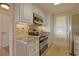 A well-lit kitchen with stainless steel appliances, granite countertops, and custom cabinets at 741 Retreat Beach Circle # B-1-F, Pawleys Island, SC 29585