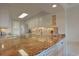 An open-concept kitchen features granite countertops, stainless steel appliances, and bright, modern lighting at 741 Retreat Beach Circle # B-1-F, Pawleys Island, SC 29585