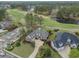 Aerial shot showcasing the home's location on the golf course, mature trees, and brick exterior details at 9278 Nw Checkerberry Square, Calabash, NC 28467