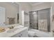 Well-lit bathroom featuring a white vanity, a mirrored cabinet, and a shower with a glass door at 9278 Nw Checkerberry Square, Calabash, NC 28467