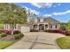 Lovely brick home featuring a paved driveway, beautiful landscaping, and a two-car garage at 9278 Nw Checkerberry Square, Calabash, NC 28467
