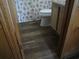 Bathroom featuring a patterned shower curtain, toilet, and wood-look vinyl flooring at 9540 Shore Dr. # 3-H, Myrtle Beach, SC 29572