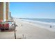 Scenic view of a sandy beach with building amenities and a distant pier at 9540 Shore Dr. # 3-H, Myrtle Beach, SC 29572