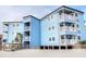 Exterior shot of a blue beachfront building with white balconies and a sandy beach at 9540 Shore Dr. # 3-H, Myrtle Beach, SC 29572