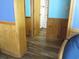 Hallway featuring wood paneled walls, wood-look vinyl flooring, leading to a bathroom and bedroom at 9540 Shore Dr. # 3-H, Myrtle Beach, SC 29572