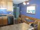 Cozy eat-in kitchen with blue accent wall, wood cabinets, and view to exterior at 9540 Shore Dr. # 3-H, Myrtle Beach, SC 29572