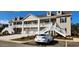 Charming two-story condo building with inviting staircases and well-maintained landscaping under a clear blue sky at 1411 Gooseneck Place # 202 Middle, Murrells Inlet, SC 29576