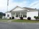 Exterior view of the clubhouse featuring white siding and a well manicured lawn at 1411 Gooseneck Place # 202 Middle, Murrells Inlet, SC 29576