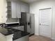 Well-appointed kitchen with stainless steel refrigerator, black granite counters, and neutral cabinets at 1411 Gooseneck Place # 202 Middle, Murrells Inlet, SC 29576