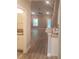 A look from the kitchen area into the home's bright living space with hardwood floors and a ceiling fan at 1411 Gooseneck Place # 202 Middle, Murrells Inlet, SC 29576