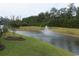 Peaceful community pond with a fountain, manicured grass, and trees at 1411 Gooseneck Place # 202 Middle, Murrells Inlet, SC 29576