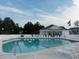 Relaxing community pool area with lounge chairs, a building with shade, and lovely landscaping at 1411 Gooseneck Place # 202 Middle, Murrells Inlet, SC 29576