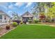 Beautiful backyard with lush lawn, covered patio, outdoor TV, and meticulously manicured landscaping at 152 Creek Harbour Circle, Murrells Inlet, SC 29576
