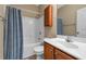 Cozy bathroom featuring a shower-tub combo with a blue patterned curtain, a toilet, and a wood vanity at 270 Moulton Dr., Longs, SC 29568
