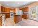 Bright kitchen with an island, white appliances, tile floors, and light wood cabinets at 270 Moulton Dr., Longs, SC 29568