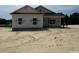 Newly constructed home with gray siding, black shutters, and an unfinished yard at 334 William Nobles Rd., Aynor, SC 29511