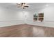 Living room with a large window, wood-look floors, a ceiling fan, and classic trim at 334 William Nobles Rd., Aynor, SC 29511