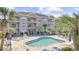Community pool surrounded by lounge chairs, palm trees, and beautiful condo buildings at 4771 Wild Iris Dr. # 204, Myrtle Beach, SC 29577