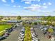 Aerial view of a full parking lot with residences along a waterfront in the background under a sunny, partly cloudy sky at 4771 Wild Iris Dr. # 204, Myrtle Beach, SC 29577