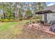 Enjoy the serene backyard with a brick patio, lush landscaping, and a peaceful setting surrounded by mature trees at 4738 Southern Trail, Myrtle Beach, SC 29579