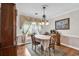 Bright dining area with hardwood floors, decorative window treatments, elegant chandelier, and antique-style decor at 4738 Southern Trail, Myrtle Beach, SC 29579