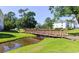 Scenic community with a charming wooden bridge over a small pond, connecting lush green spaces and nearby buildings at 569 Blue River Ct. # 9-A, Myrtle Beach, SC 29579