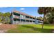 Exterior view of blue apartments with balconies, grassy grounds, and palm trees at 610 Putters Ln. # H-109, Little River, SC 29566