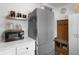 Compact kitchen with stainless steel refrigerator and open shelving for storage, along with a small table at 610 Putters Ln. # H-109, Little River, SC 29566