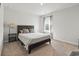 Bedroom with a wooden bed frame, side table and a large window with sheer curtains at 7037 Grant St., Little River, SC 29566