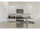 Close up view of the kitchen sink, stainless appliances, granite counters, and white cabinets, showcasing modern design at 7037 Grant St., Little River, SC 29566