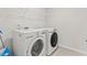 Clean laundry area with white washer and dryer set and wire shelving for storage at 7037 Grant St., Little River, SC 29566